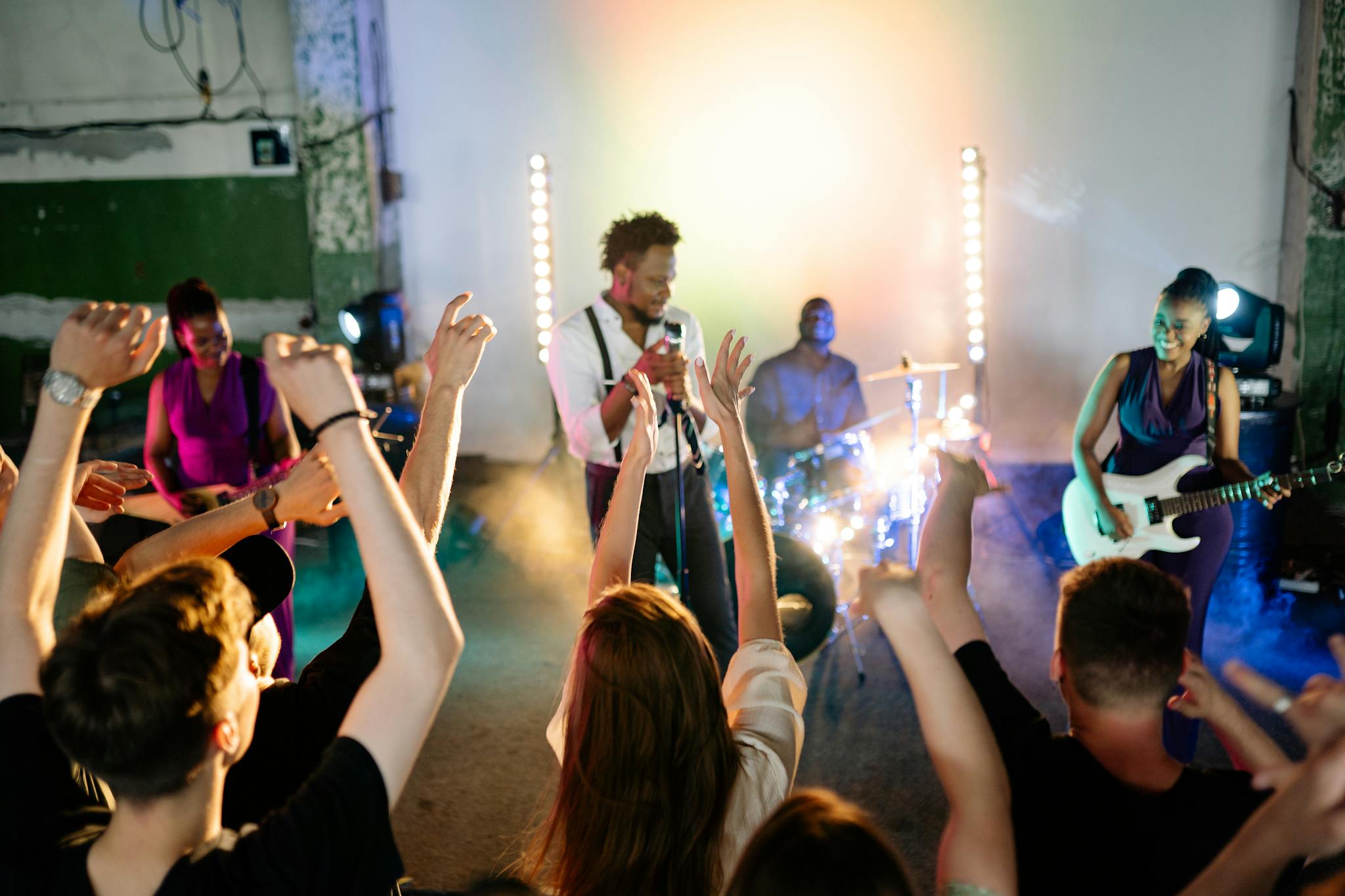 A lively band performance in a nightclub with a cheering crowd enjoying the vibrant music.